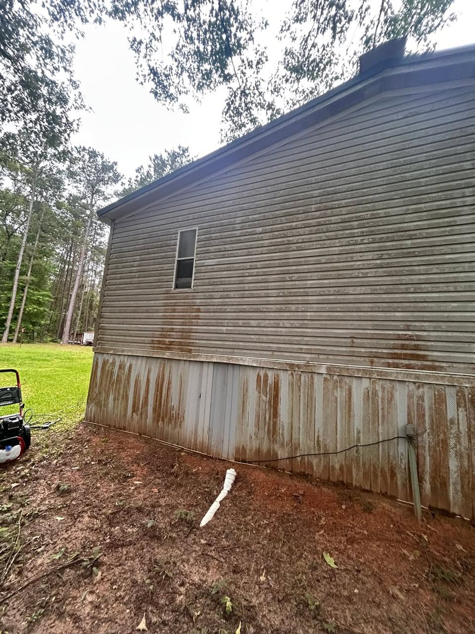 Home siding with heavy rust staining before pressure washing